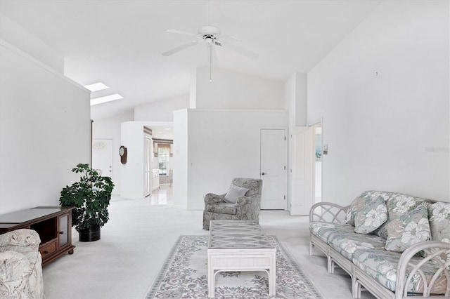 living room with a skylight, high vaulted ceiling, a ceiling fan, and light colored carpet