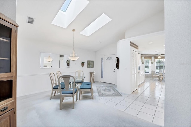 dining area with light carpet, vaulted ceiling, visible vents, and light tile patterned floors