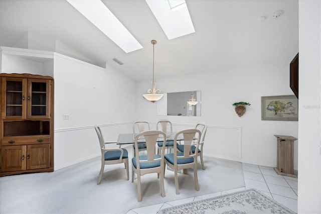 dining space with vaulted ceiling with skylight, visible vents, baseboards, and light tile patterned floors