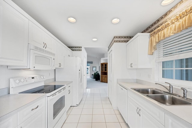 kitchen featuring white appliances, light countertops, and a sink