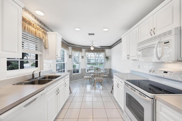 kitchen with white appliances, light countertops, and a sink