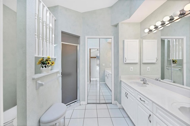 bathroom with tile patterned flooring, toilet, a sink, double vanity, and a stall shower