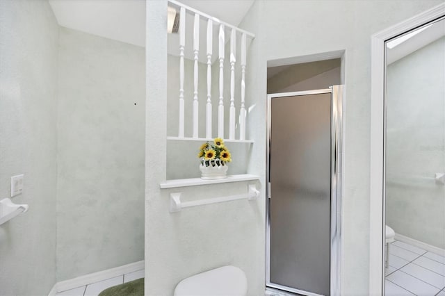 full bathroom featuring toilet, a stall shower, baseboards, and tile patterned floors