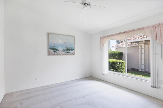 carpeted spare room featuring ceiling fan, lofted ceiling, and baseboards