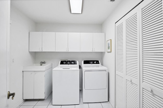 washroom featuring light tile patterned flooring, separate washer and dryer, a sink, visible vents, and cabinet space