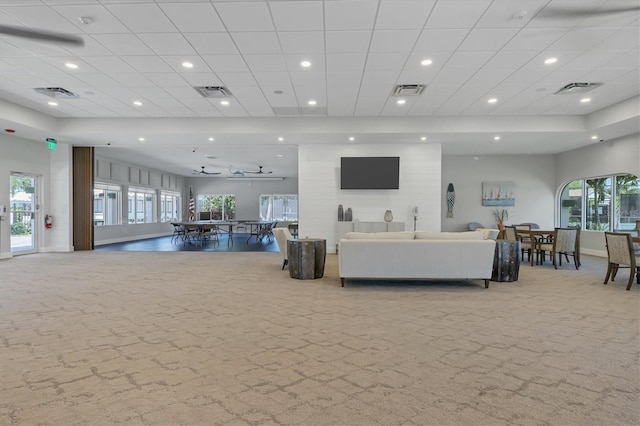 living room with carpet flooring, visible vents, and a healthy amount of sunlight