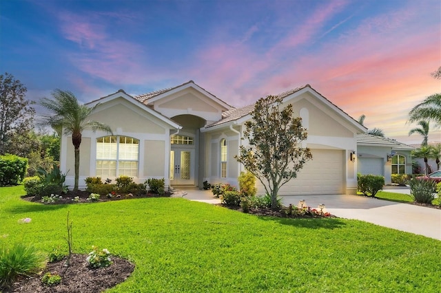 ranch-style home with a garage, driveway, french doors, stucco siding, and a front yard