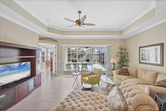 living area featuring a tray ceiling, ornamental molding, a ceiling fan, a sunroom, and light tile patterned flooring