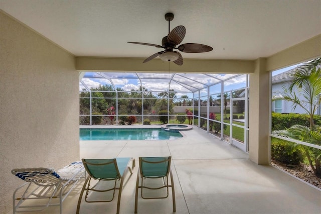 view of pool with ceiling fan, a patio, a lanai, and a pool with connected hot tub