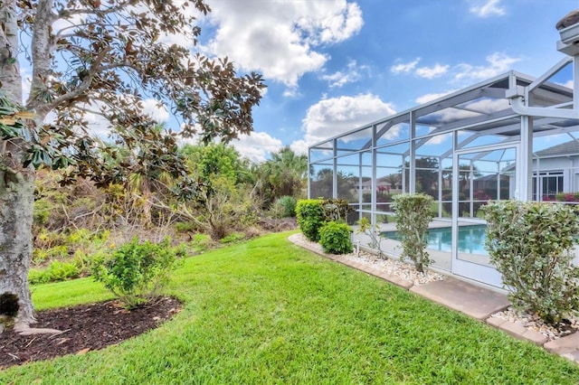 view of yard with glass enclosure and an outdoor pool