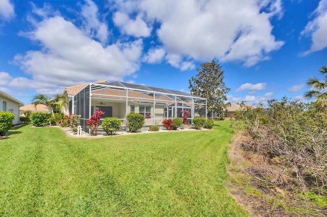 back of house featuring a yard and glass enclosure