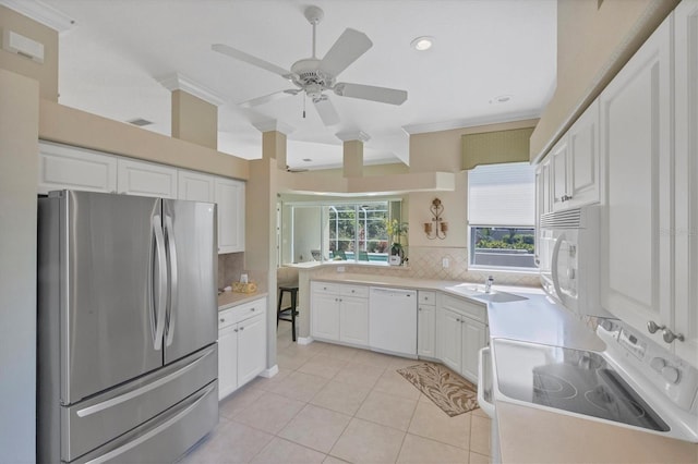 kitchen featuring white appliances, a sink, white cabinetry, and decorative backsplash