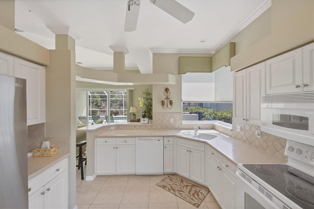 kitchen with light countertops, white appliances, a healthy amount of sunlight, and tasteful backsplash