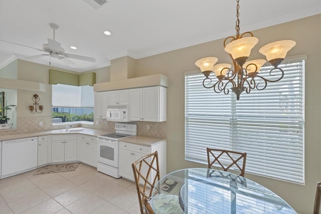 kitchen with white appliances, light countertops, crown molding, and decorative backsplash