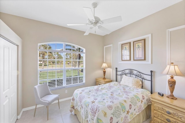 bedroom with light tile patterned floors, a ceiling fan, baseboards, and a closet