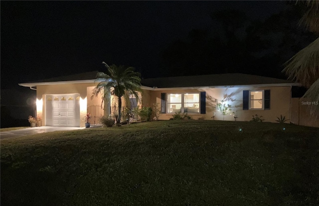 ranch-style home with an attached garage and a yard