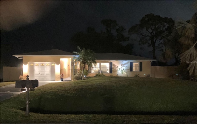 ranch-style home with a yard, an attached garage, and driveway