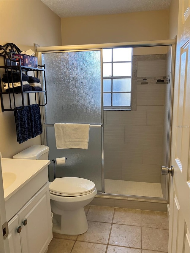 full bath featuring tile patterned flooring, a stall shower, toilet, and vanity