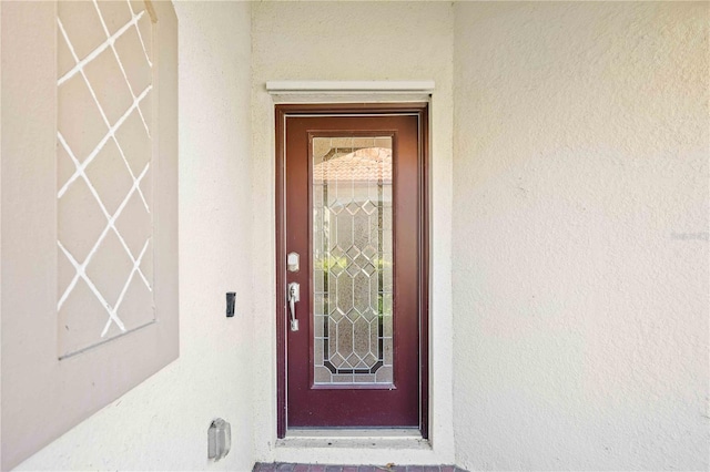 entrance to property featuring stucco siding