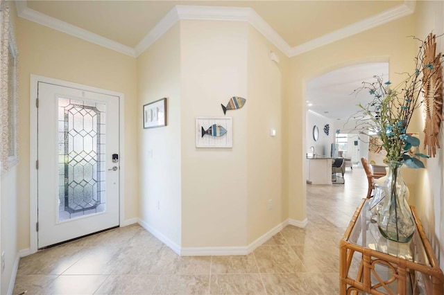 foyer entrance featuring baseboards, light tile patterned flooring, and crown molding