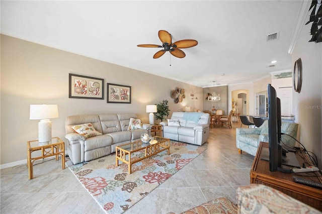 living room with baseboards, visible vents, arched walkways, a ceiling fan, and ornamental molding