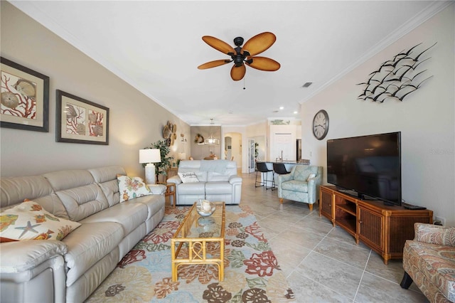 living area featuring visible vents, arched walkways, ceiling fan, crown molding, and light tile patterned flooring