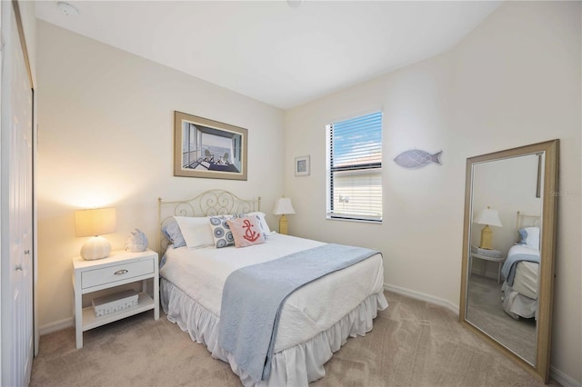 bedroom with light carpet and baseboards