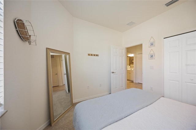 bedroom featuring baseboards, a closet, visible vents, and light colored carpet