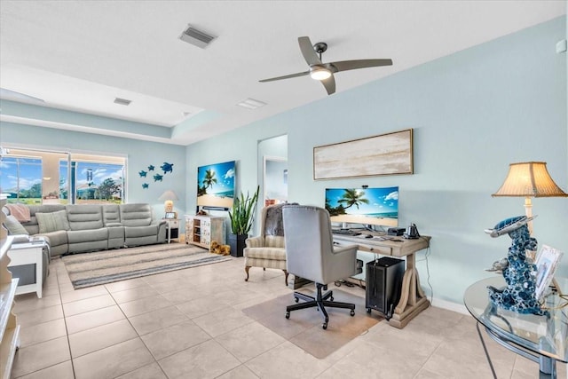 tiled home office featuring visible vents, baseboards, a tray ceiling, and a ceiling fan