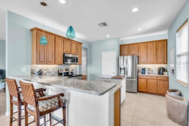 kitchen featuring visible vents, pendant lighting, appliances with stainless steel finishes, a peninsula, and light tile patterned flooring