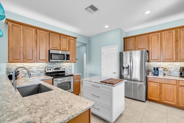 kitchen with visible vents, light stone countertops, appliances with stainless steel finishes, light tile patterned flooring, and a sink