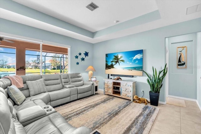 tiled living room featuring a raised ceiling, baseboards, and visible vents