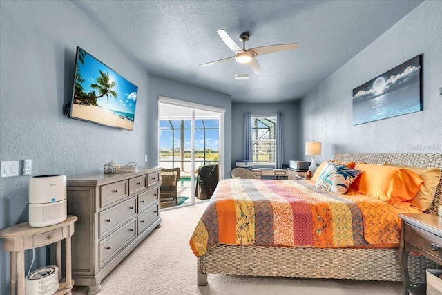 bedroom featuring visible vents, a textured wall, a textured ceiling, access to outside, and light colored carpet