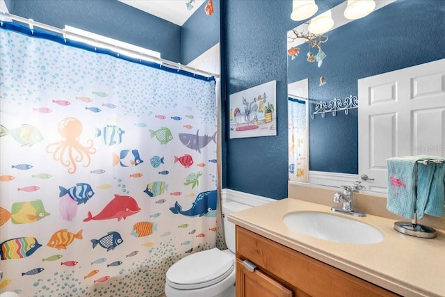 bathroom with vanity, toilet, a shower with curtain, and a textured wall