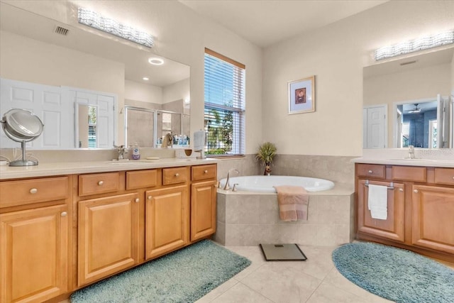 bathroom with tile patterned floors, a stall shower, a garden tub, and a sink