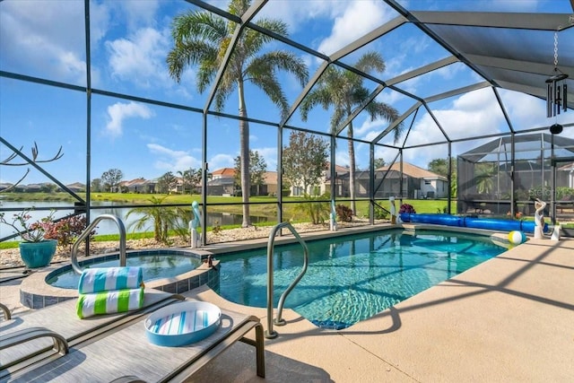 view of swimming pool with glass enclosure, a pool with connected hot tub, a patio, and a water view