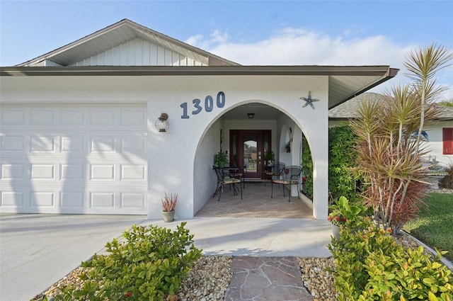 property entrance featuring a garage and stucco siding