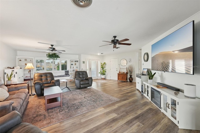 living area with visible vents, wood finished floors, and a ceiling fan