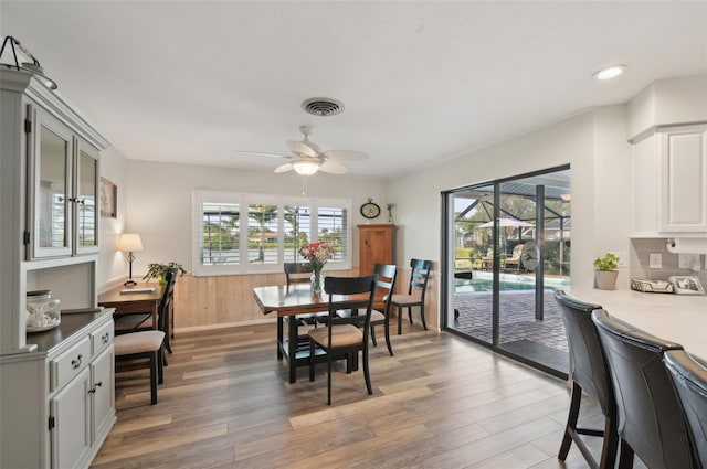 dining room with light wood-style flooring, visible vents, and ceiling fan