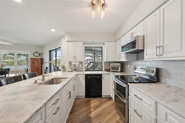 kitchen with decorative backsplash, appliances with stainless steel finishes, light wood-style floors, white cabinetry, and a sink