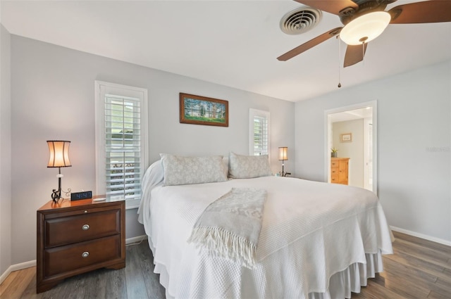 bedroom featuring visible vents, ceiling fan, baseboards, and wood finished floors