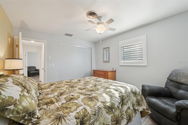 bedroom featuring ceiling fan, visible vents, and a closet