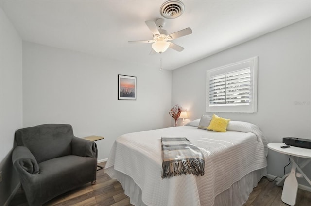 bedroom featuring visible vents, ceiling fan, baseboards, and wood finished floors