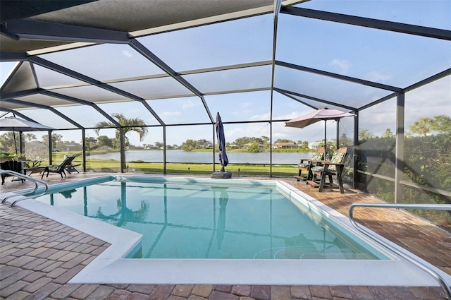 pool with glass enclosure, a patio area, and a water view