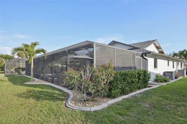 view of home's exterior featuring central air condition unit, glass enclosure, a shingled roof, and a lawn