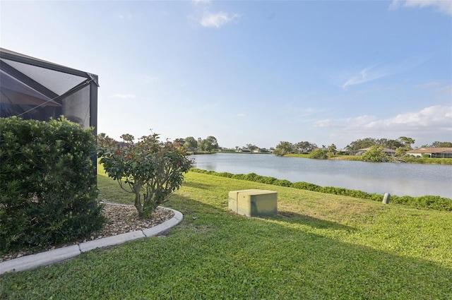 view of yard with a water view and glass enclosure