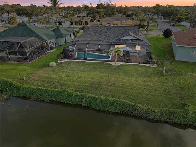 aerial view at dusk with a residential view and a water view