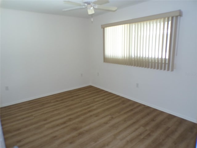 unfurnished room with plenty of natural light, baseboards, and wood finished floors