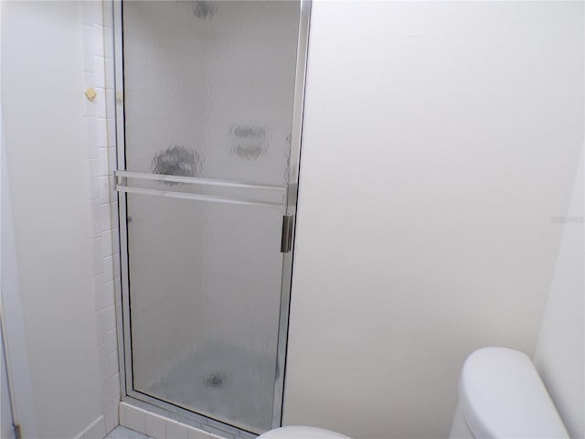 full bathroom with a shower stall and toilet