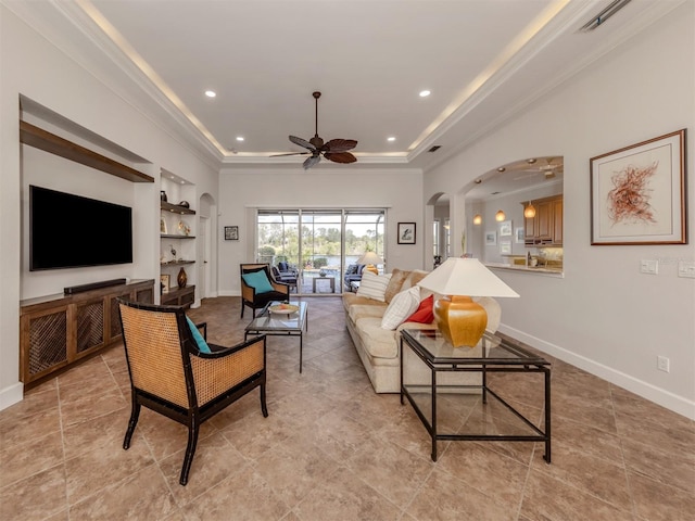 living area featuring arched walkways, recessed lighting, a raised ceiling, visible vents, and baseboards